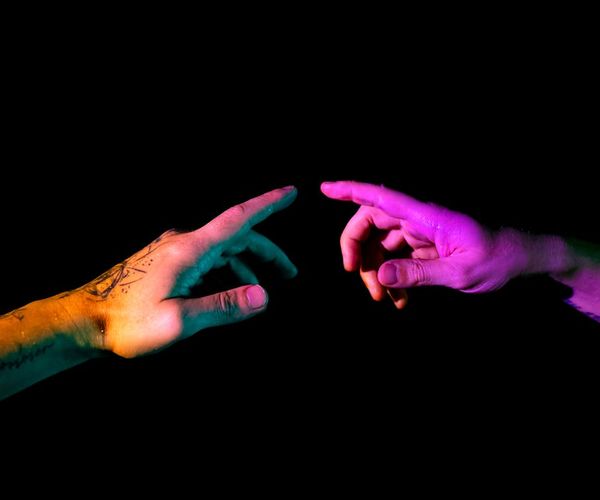 Close-up of a person's hands in a symbolic mudra gesture.