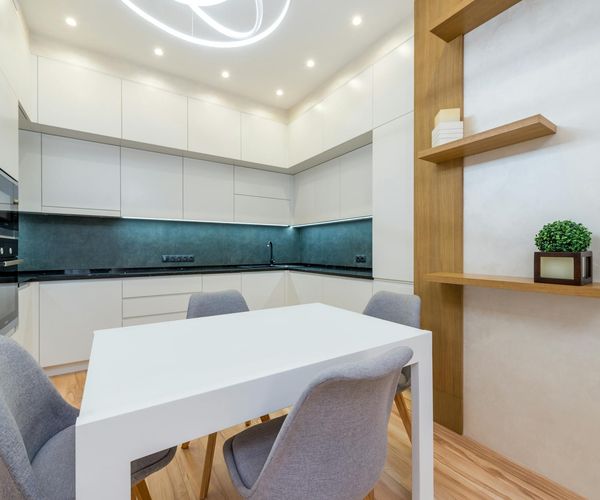 Interior of a bright and spacious yoga studio with wooden floors and plants.