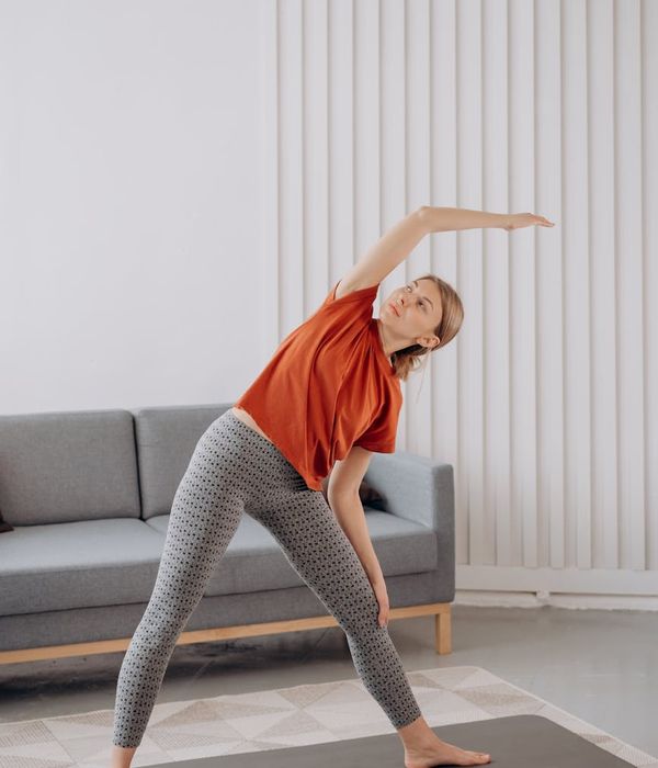 Woman in a calm yoga pose in a beautifully lit room.